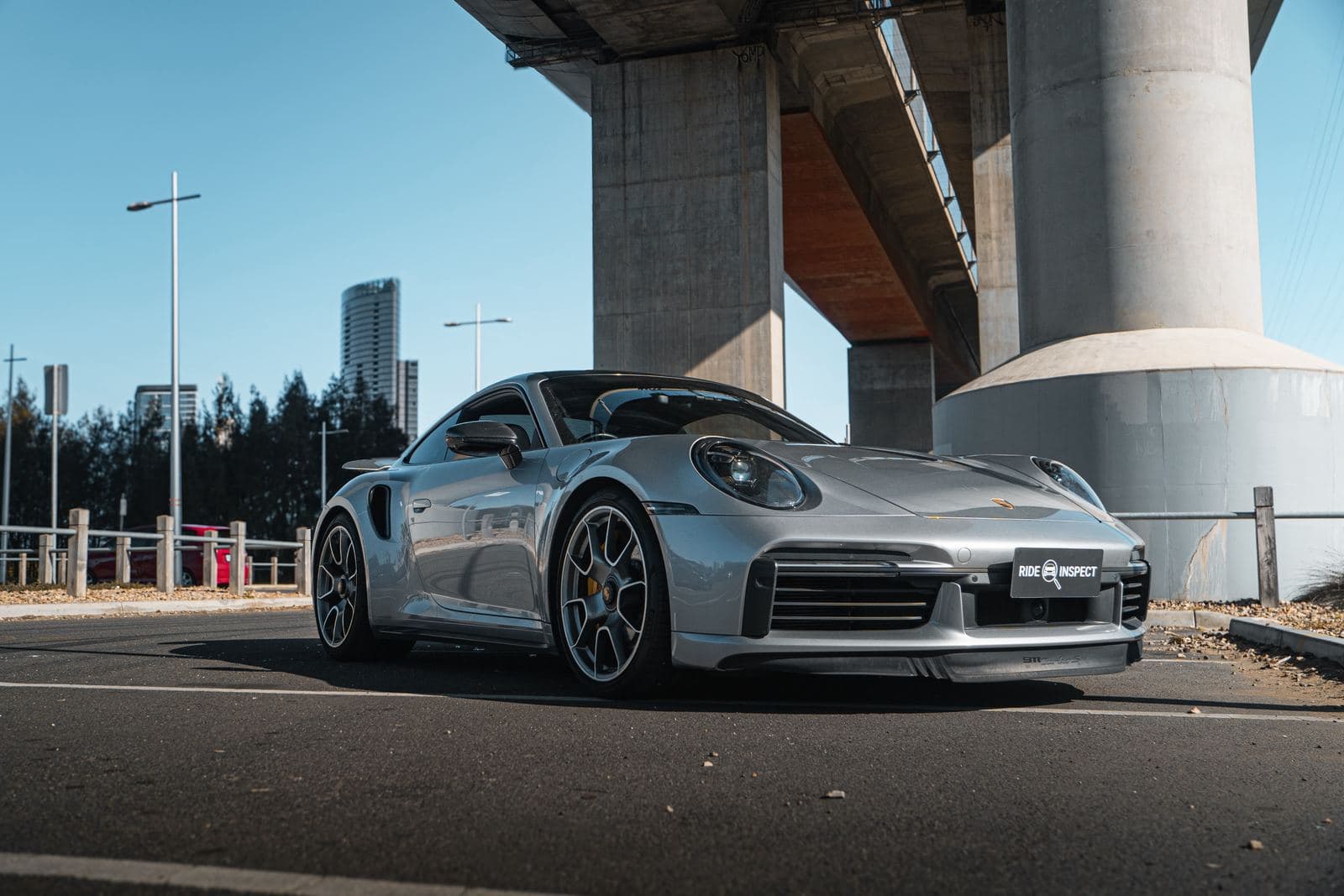 Silver Porsche 911 parked under an overpass before a Ride Inspect inspection
