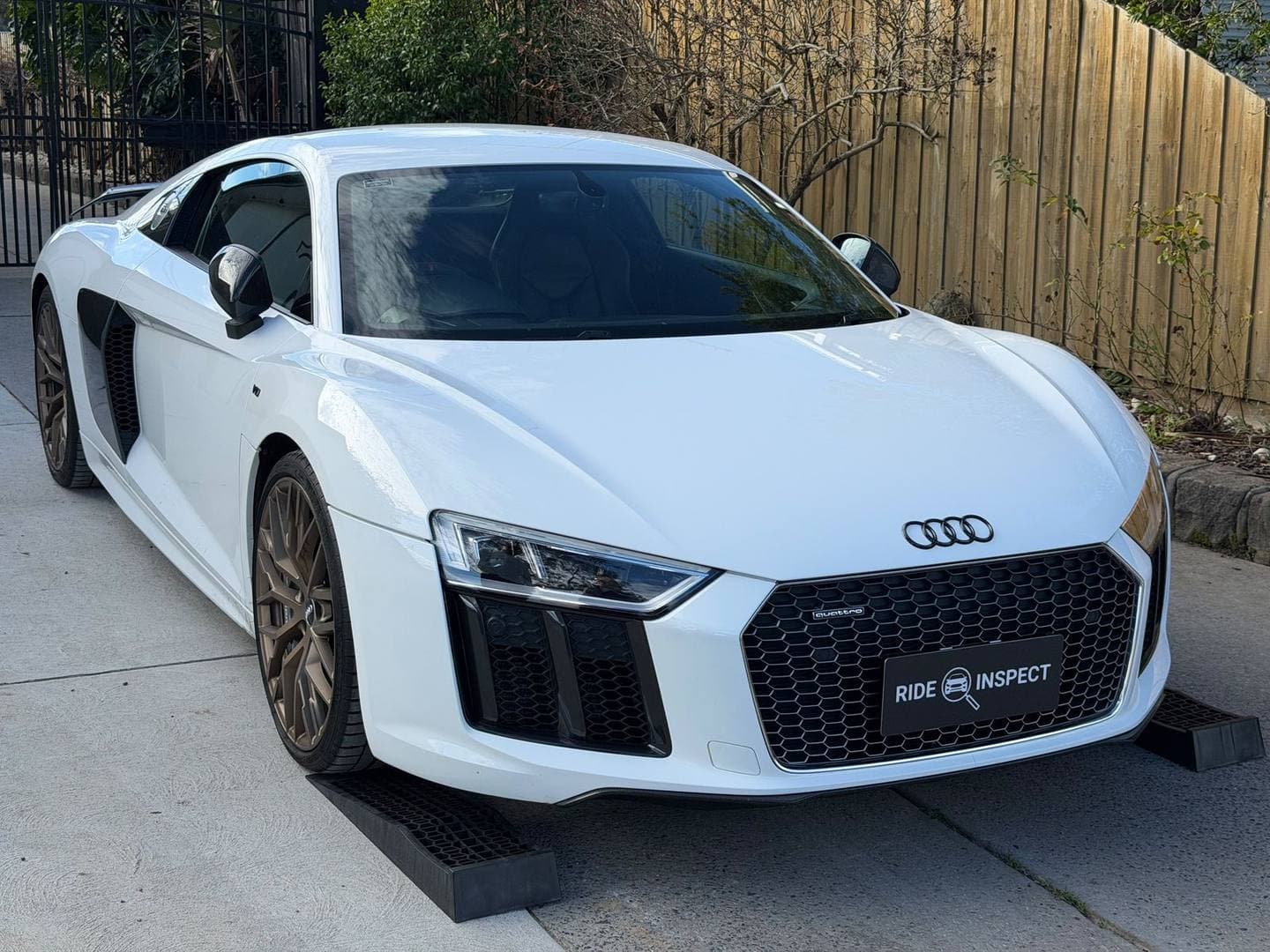 White Audi R8 in a driveway with a Ride Inspect plate cover